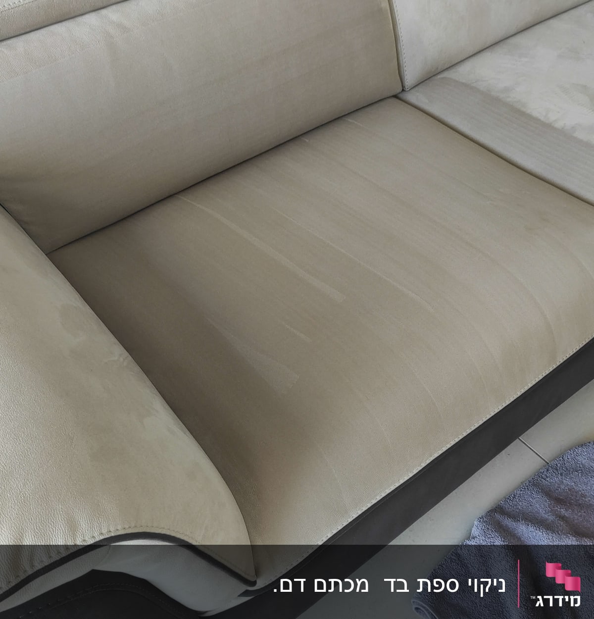 ספה בהירה עם מגבת כחולה על הרצפה